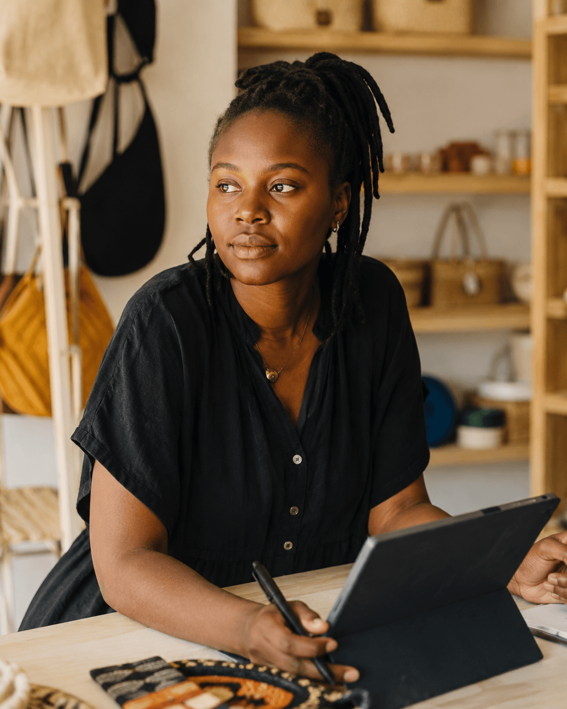 A Kenyan business owner working in her boutique, the kind of business SyntaxCape builds for